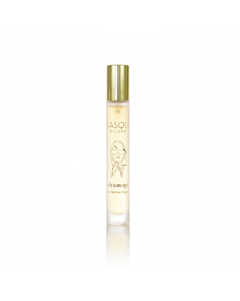 A glass bottle of Masque Milano fragrance titled "Dolceacqua" with a gold cap, featuring a printed illustration and label text. This limited edition, 100ml hand-numbered bottle stands elegantly against a white background.