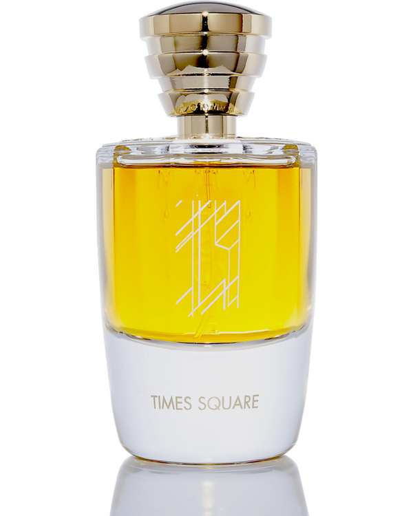 A clear glass bottle of Masque Milano's Times Square perfume containing golden liquid, adorned with a golden cap and a geometric design on the front. This elegant fragrance captures the essence of New York's vibrant city miasmas.