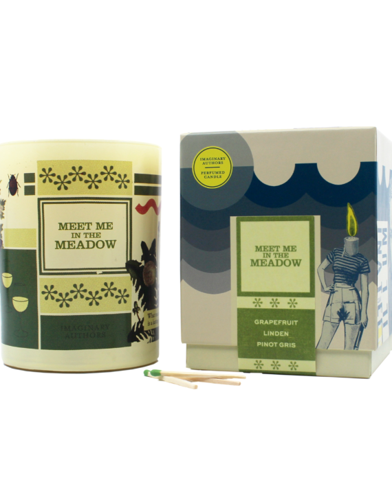 The "Meet Me In The Meadow" candle from Imaginary Authors is positioned next to its matching box. This candle boasts a soy blend scent of grapefruit, linden, and pinot gris. Two green-tipped matches lie in front of it, and it offers a 60-hour burn time.