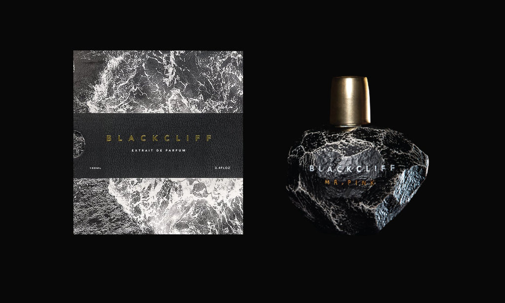Close-up of Mr. Pink Extrait De Parfum packaging and bottle by Blackcliff. The packaging features a black and white marbled design, while the bottle has a black, textured surface with a gold cap. This mystical gourmand perfume subtly marks the manhood transition, blending elegance with depth.