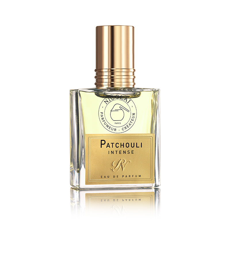 A glass bottle of "Patchouli Intense" perfume by Nicolaï, adorned with a gold cap and logo, stands reflective against a white background. The label, signifying it as an eau de parfum, hints at the rich blend of patchouli and subtle undertones of incense.