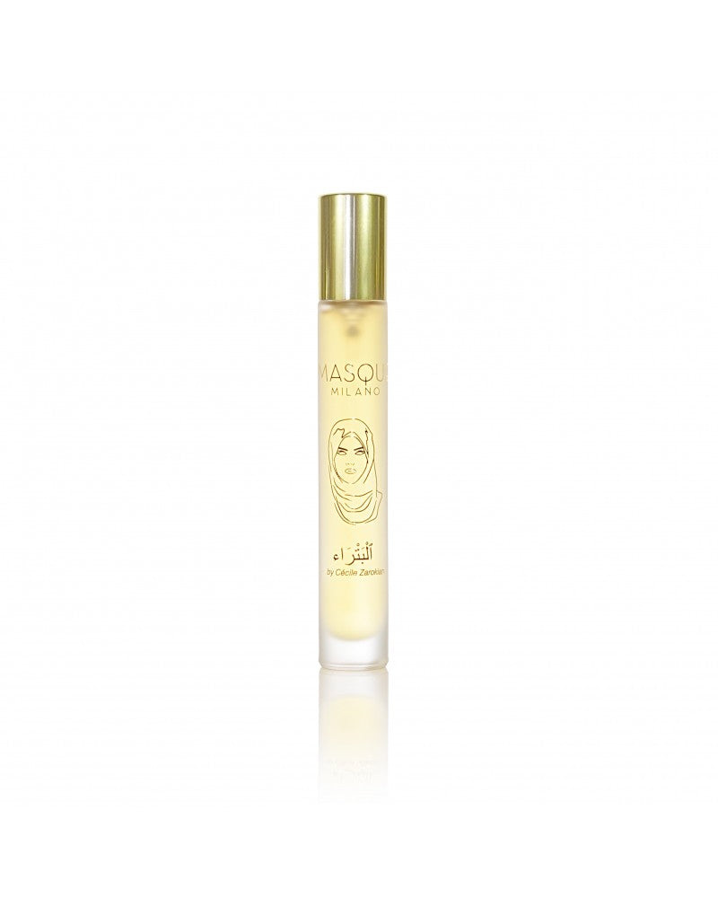 A cylindrical perfume bottle with a golden cap labeled "Petra" by Masque Milano, featuring an illustration of a face on the front, celebrates the brand's 10th anniversary limited edition. Adorned with notes of incense and patchouli, this exclusive fragrance comes in hand-numbered bottles to enhance its unique charm.
