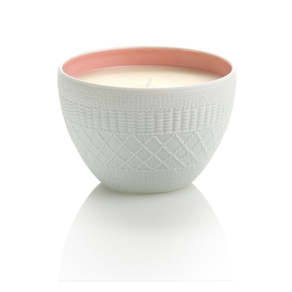 The Rose Trocadéro by Le Jardin Retrouvé is a white ceramic candle holder with textured patterns and a pink interior, reminiscent of a floral Eau de Parfum, containing a single-wick white candle.
