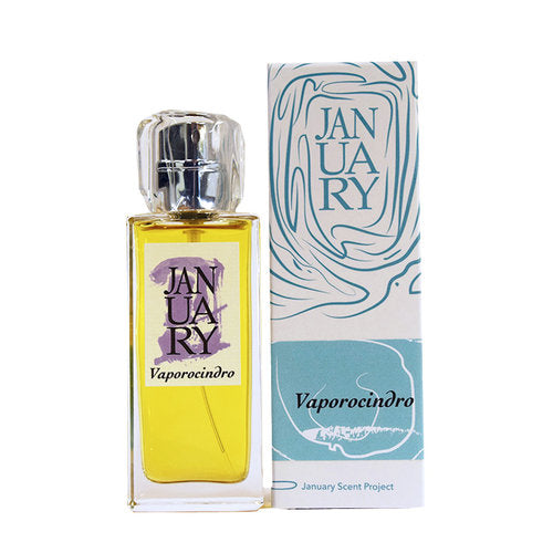 A bottle of January Scent Project Vaporocindro perfume is displayed next to its light blue and white packaging box. The bottle features a silver cap, a purple label, and captures the essence of spice and wood.